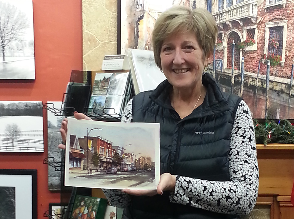 Gallery customer with the commissioned portrait of her childhood home in Preston Ontario