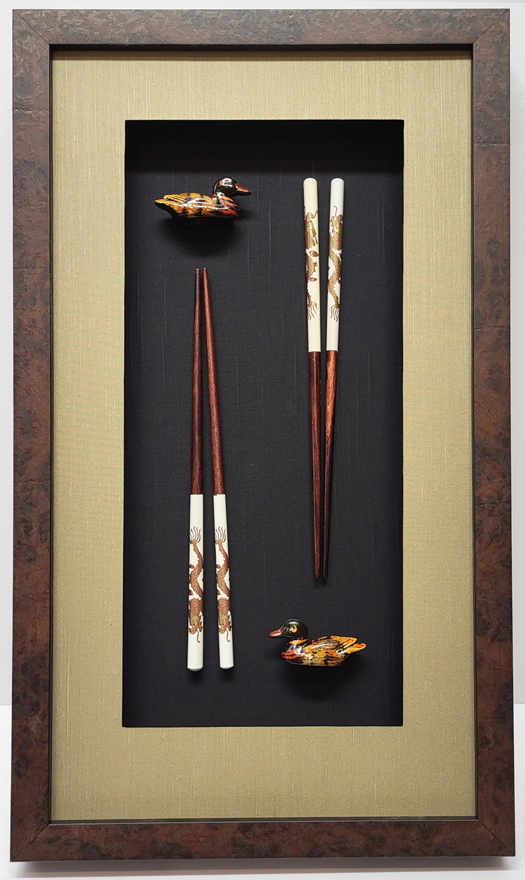 Japanese chopsticks framed with taupe silk top mat, black silk bottom mat, and brown textured frame