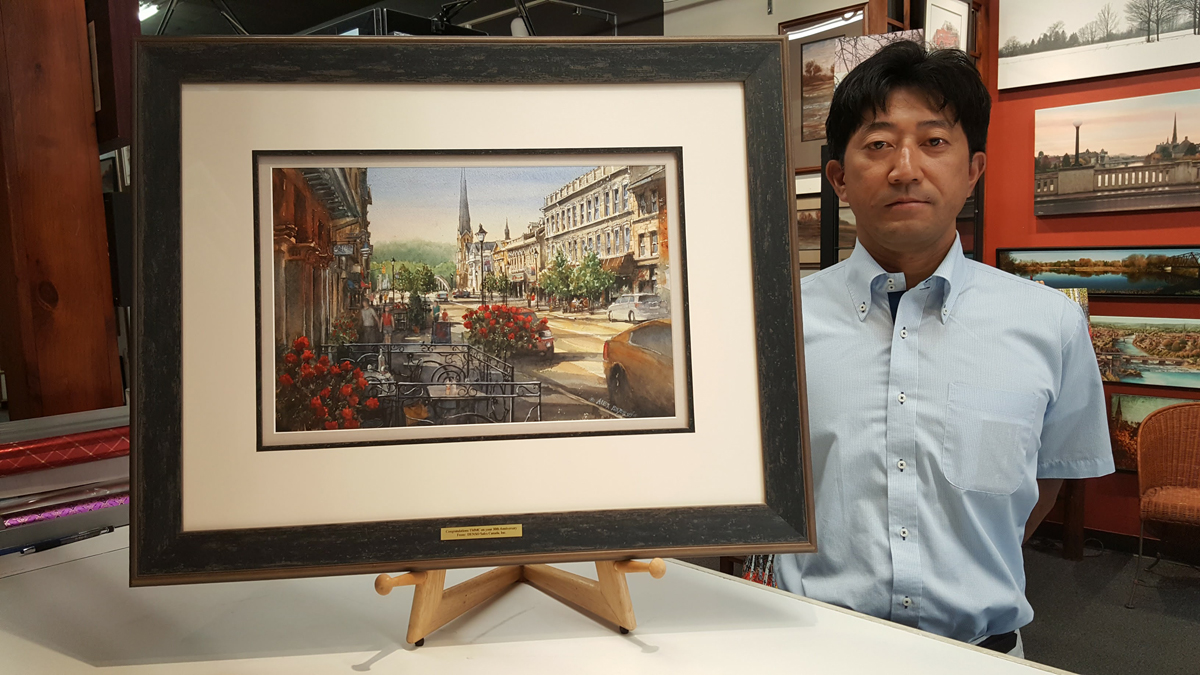 Original Painting by Alex Krajewski Walking Down Main Street custom framed by Krajewski Gallery and presented as a corporate gift to a local car company