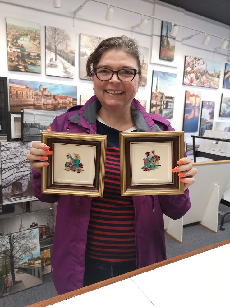 Happy customer picking up their vintage needleworks framed by Krajewski Gallery