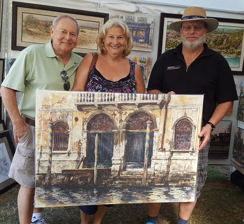 Canadian artist Alex Krajewski at a show with happy customers